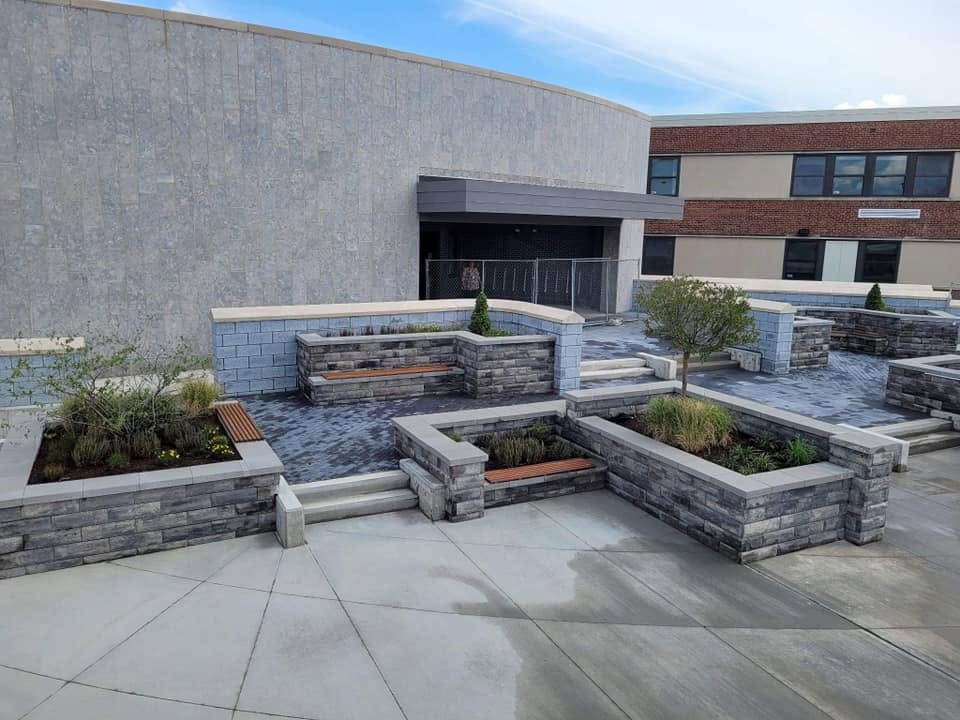 Commercial hardscape terrace with block planters, steps, and benches